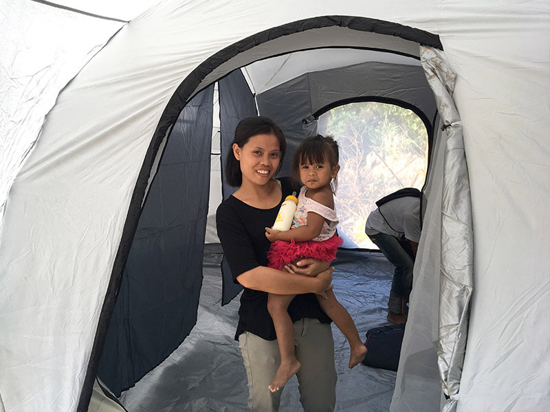 Woman holding her child in SB USA tent