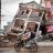 2 people on a motorcycle pass by a tilted, destroyed building in Nepal after the 2015 earthquake