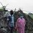A man and a woman wearing medical face masks stand in front of a damaged home in India