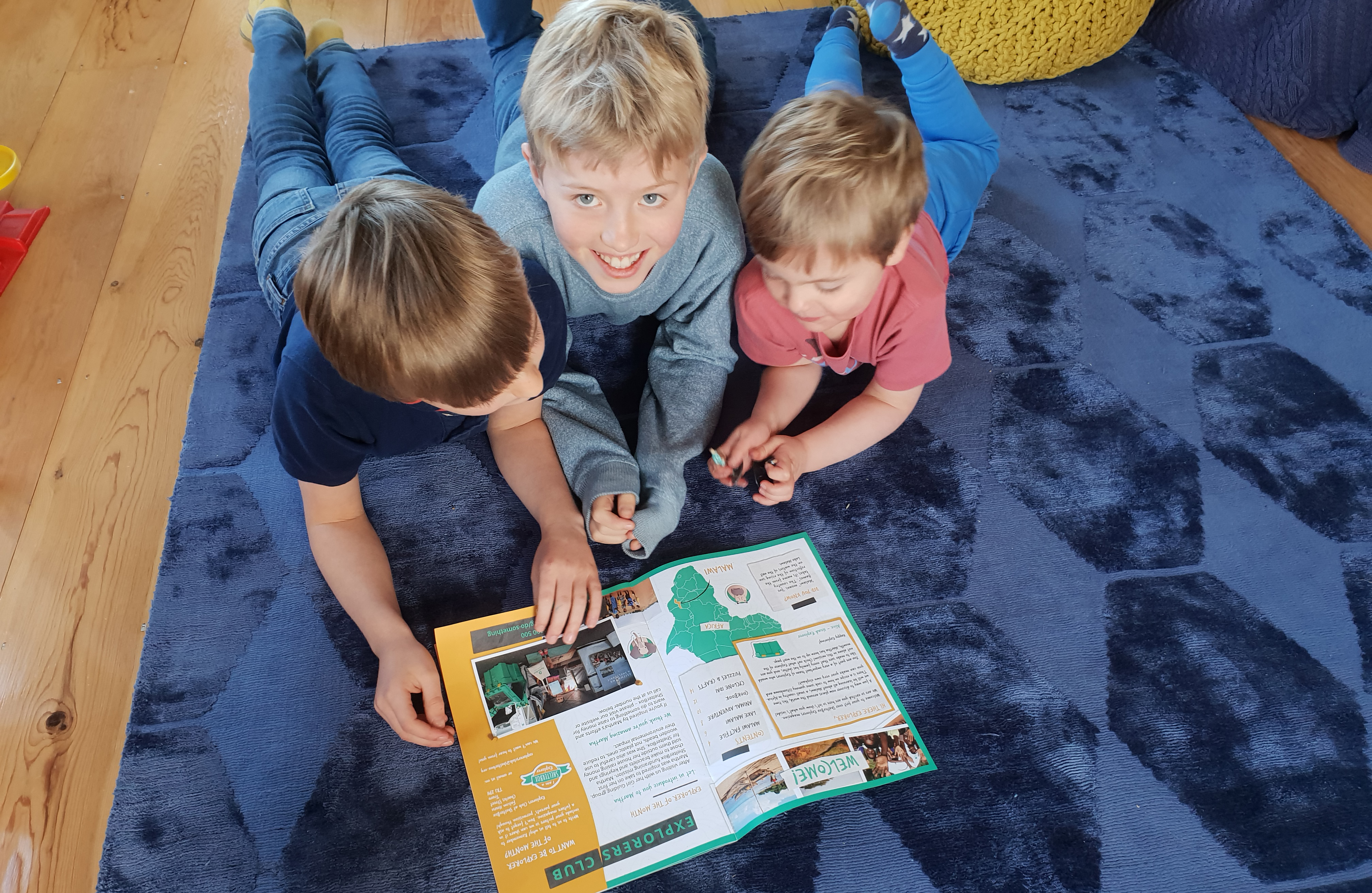 3 children looking at a magazine