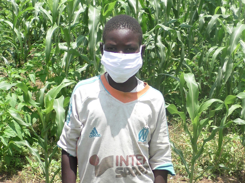 Young boy wearing a white face mask