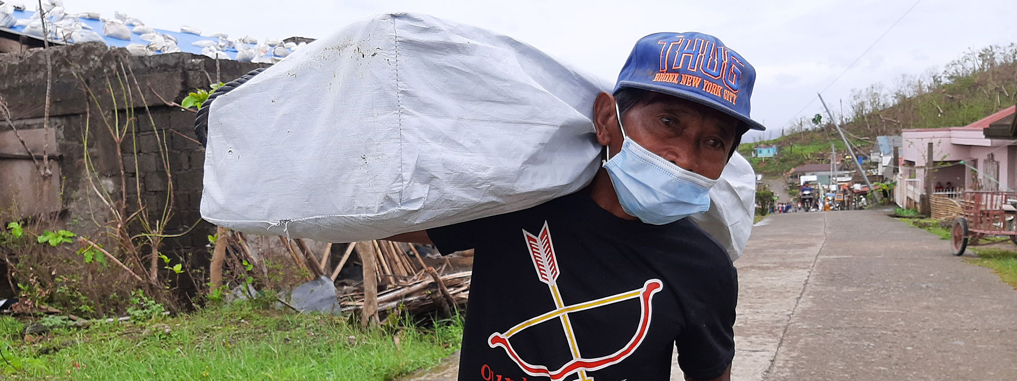 man carrying shelterbox aid in philippines