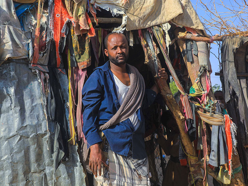 Yemeni man stands outside shelter