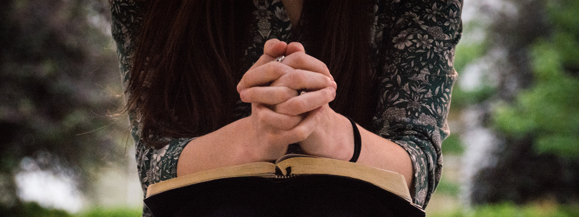 a person with a book on their lap praying