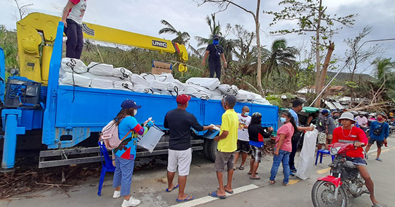 People off-loading shelter kits from a truck.