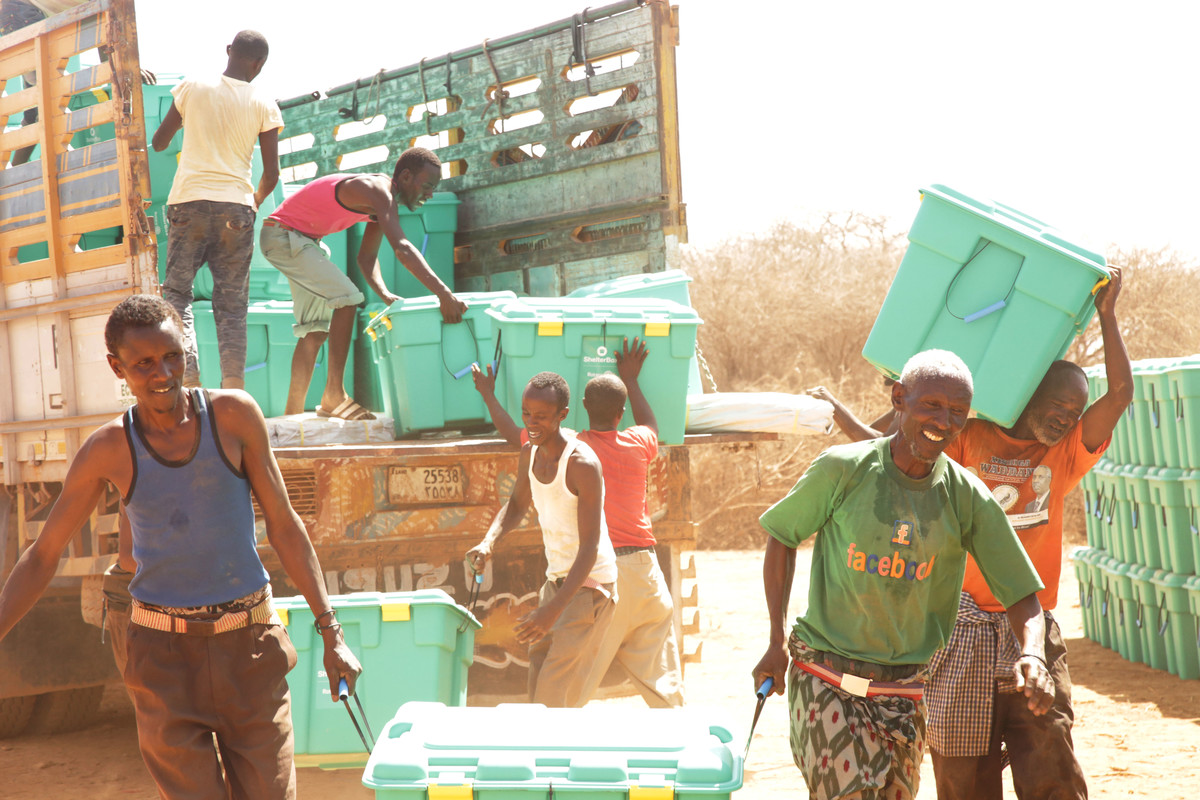 People unloading green boxes off a truck