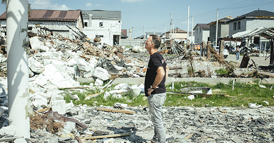 Man looking up at destroyed buildings